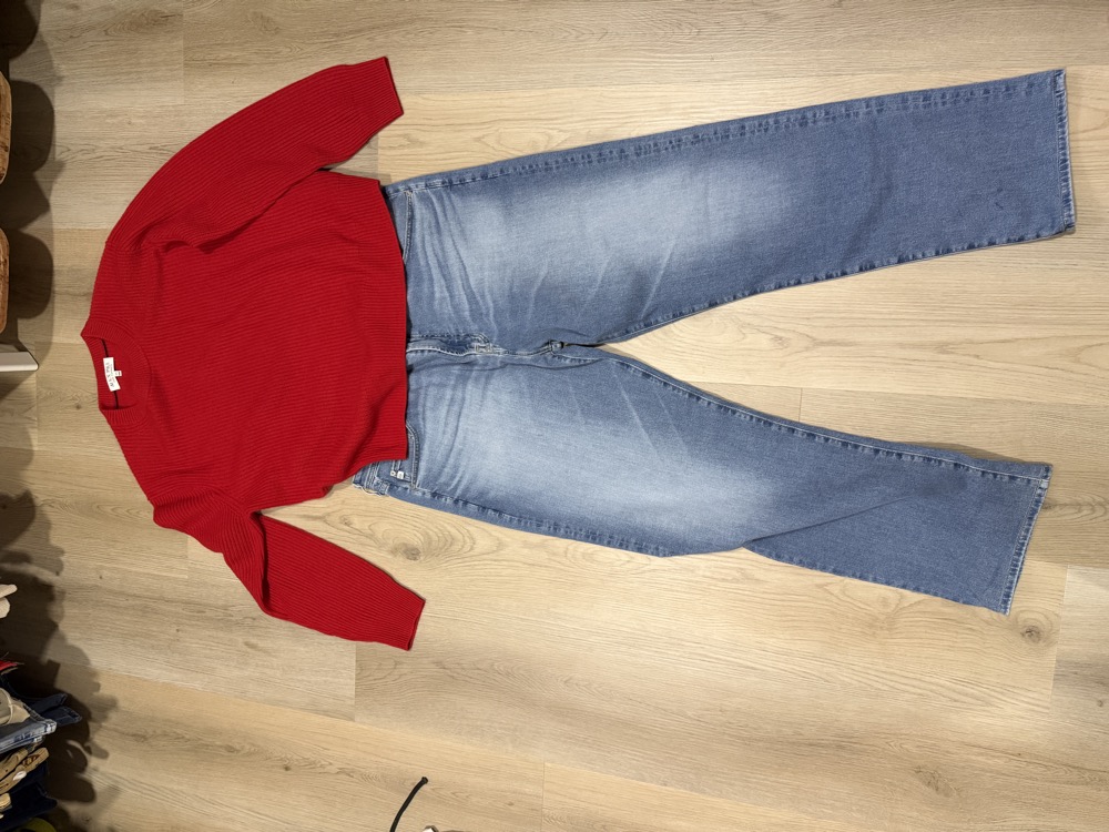 A sweater and jeans laid flat on the floor